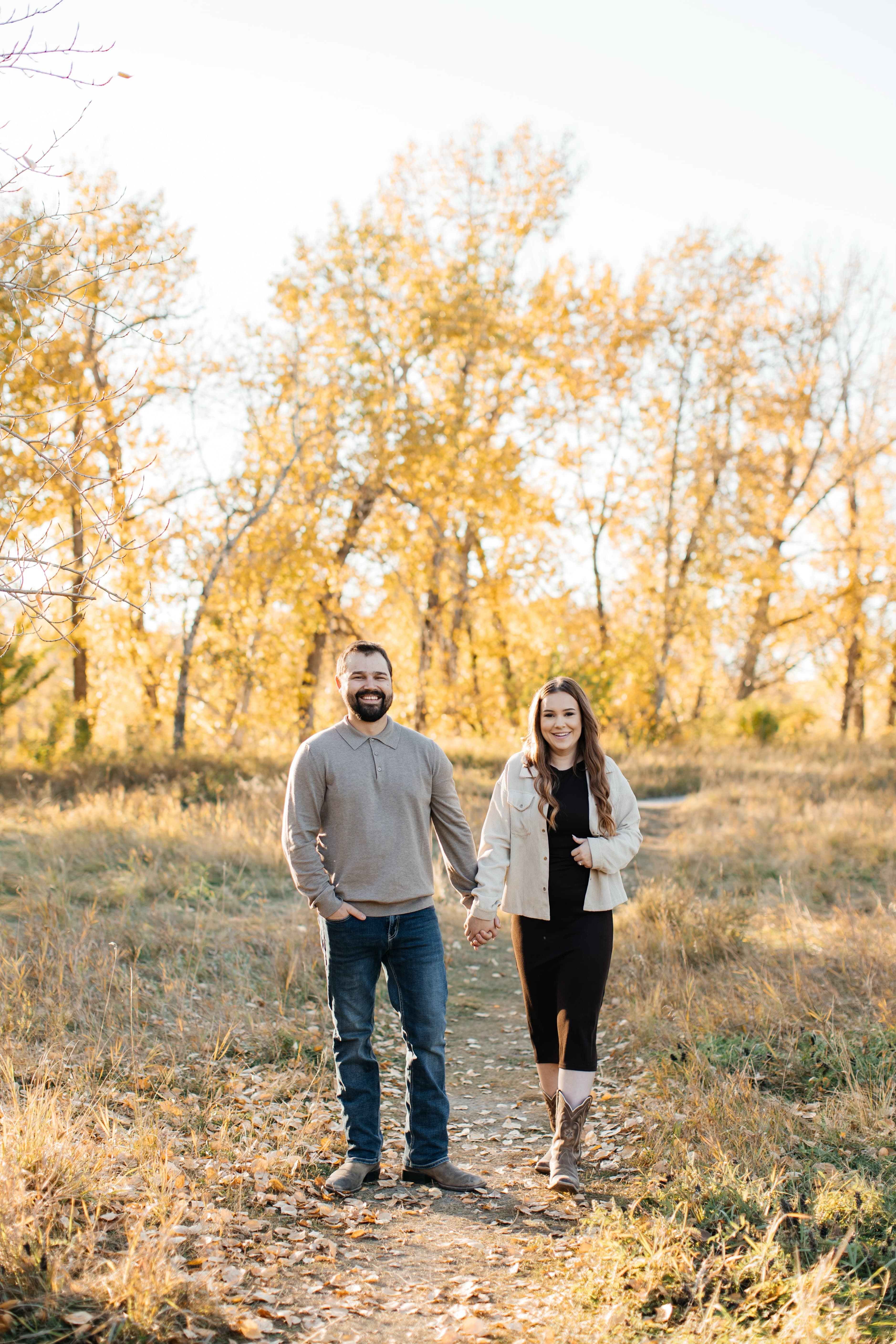 Victoria and Riley holding hands on a forest path